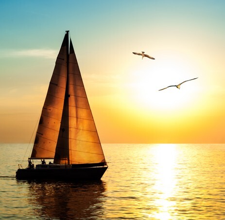 Yacht sailing against sunset